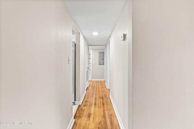 hallway featuring electric panel and light hardwood / wood-style floors