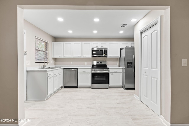 kitchen with white cabinets, stainless steel appliances, and sink