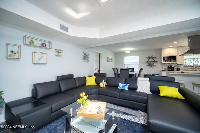 living room with a textured ceiling and sink