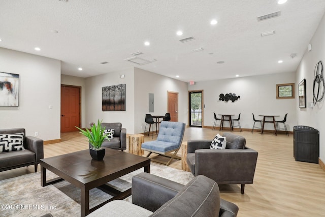 living room featuring light wood-type flooring and a textured ceiling