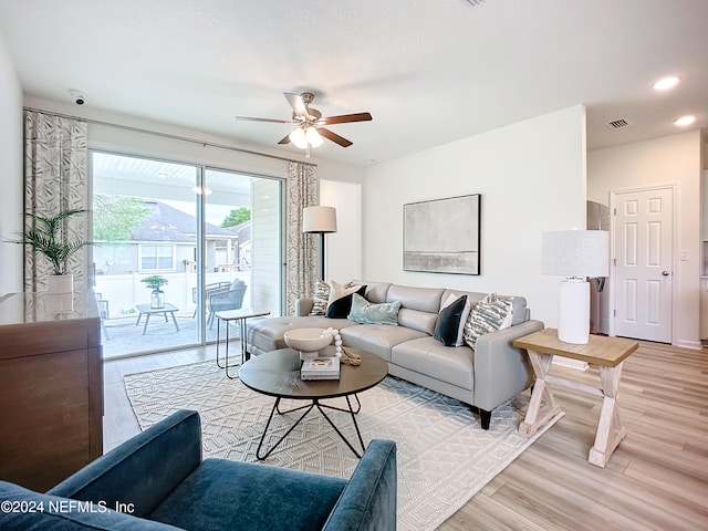 living room with light hardwood / wood-style flooring and ceiling fan