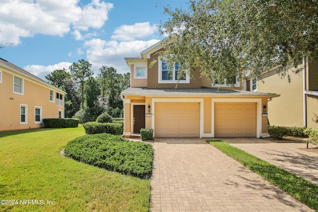 8495 Little Swift Cir, Jacksonville, FL 32256 - view of front of property with an attached garage, stucco siding, a front lawn, and decorative driveway