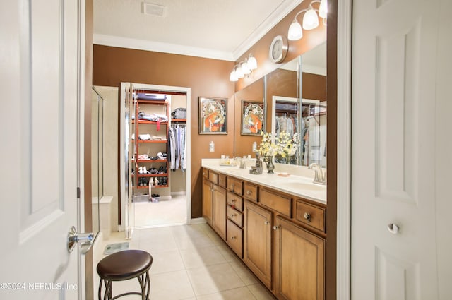 bathroom with a textured ceiling, ornamental molding, tile patterned flooring, and vanity