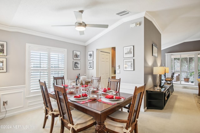 carpeted dining area featuring crown molding, vaulted ceiling, and ceiling fan