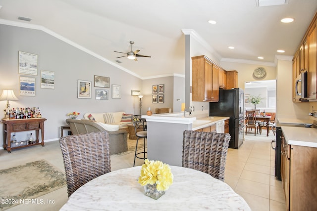 dining room featuring ceiling fan, light tile patterned flooring, lofted ceiling, and crown molding