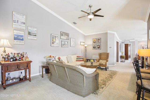 living room featuring lofted ceiling, ornamental molding, ceiling fan, and light colored carpet