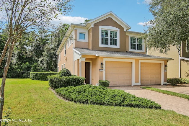 8495 Little Swift Cir, Jacksonville, FL 32256 - view of front of home with a garage, a front yard, stucco siding, and decorative driveway