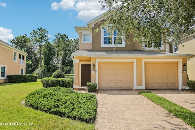 view of front of property with a garage and a front lawn