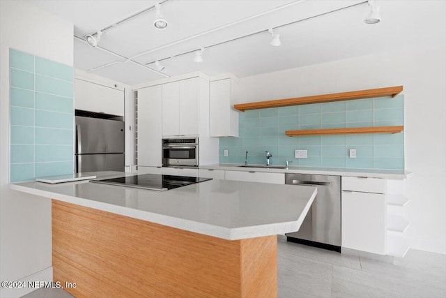 kitchen featuring decorative backsplash, sink, white cabinetry, and stainless steel appliances