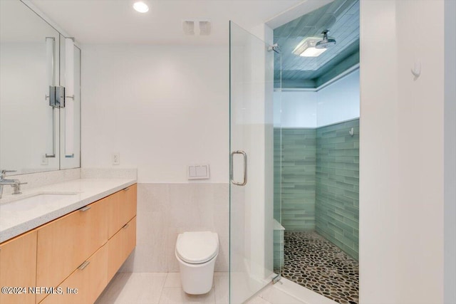 bathroom with tile patterned floors, vanity, a shower with shower door, and toilet