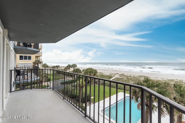 balcony featuring a view of the beach and a water view