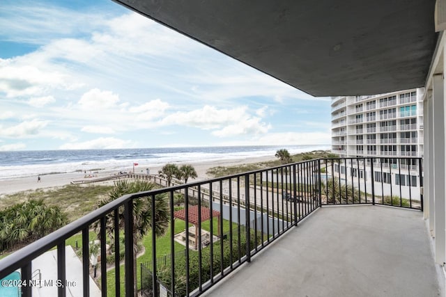 balcony with a water view and a beach view