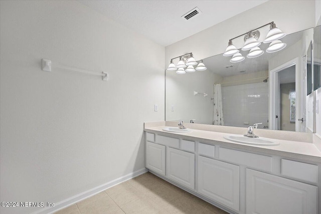 bathroom with walk in shower, tile patterned flooring, and vanity