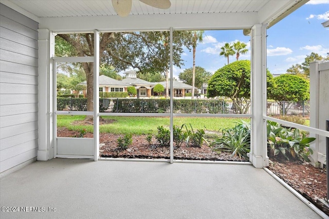 unfurnished sunroom with ceiling fan and plenty of natural light