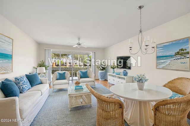 living room with hardwood / wood-style flooring and ceiling fan with notable chandelier