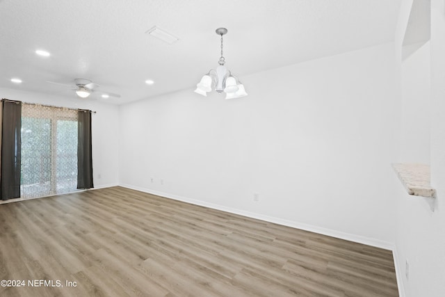 unfurnished room with ceiling fan with notable chandelier, baseboards, wood finished floors, and recessed lighting