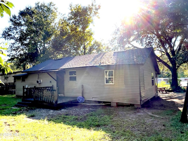 rear view of house with a wooden deck and a lawn