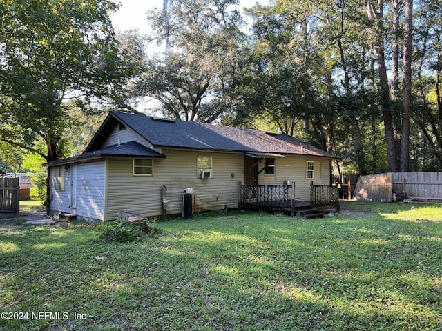 rear view of house with a lawn and a wooden deck