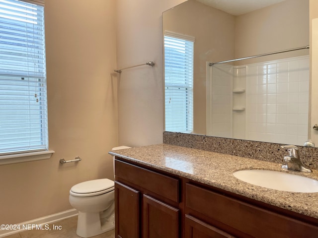 bathroom with a shower, tile patterned flooring, vanity, and toilet