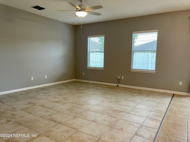 unfurnished room with a textured ceiling and ceiling fan