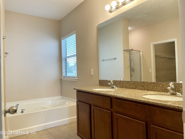 bathroom with tile patterned floors, vanity, plus walk in shower, and a textured ceiling