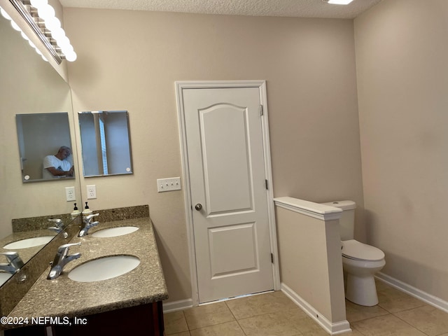 bathroom with tile patterned floors, vanity, toilet, and a textured ceiling