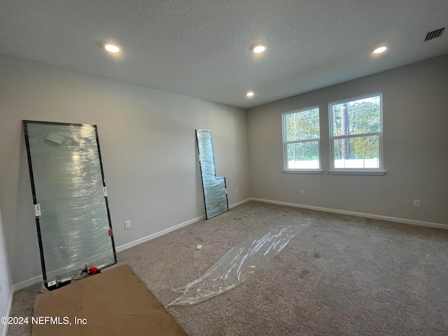 unfurnished bedroom with carpet floors and a textured ceiling