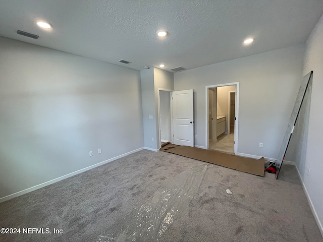 unfurnished bedroom featuring light colored carpet and a textured ceiling