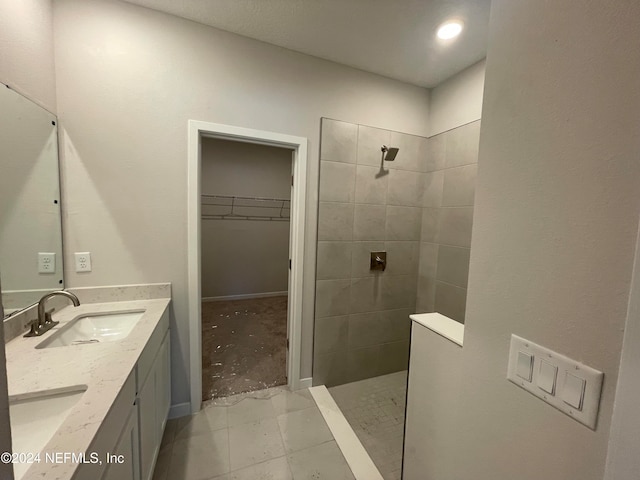 bathroom with vanity, tile patterned flooring, and a tile shower