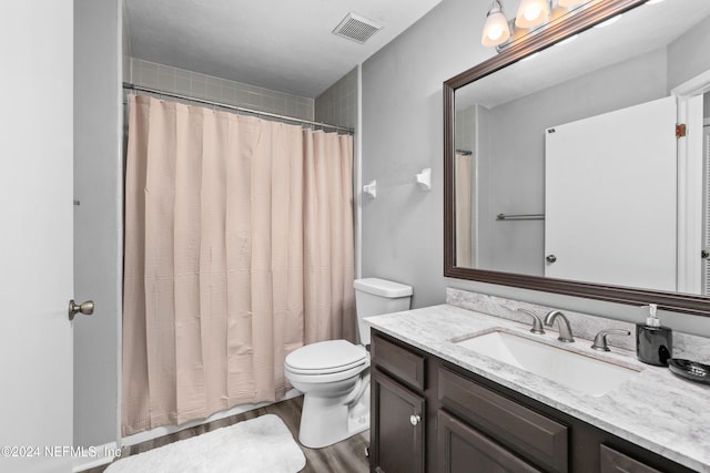 bathroom featuring hardwood / wood-style floors, a shower with curtain, vanity, and toilet