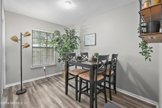 dining area featuring hardwood / wood-style flooring and a textured ceiling