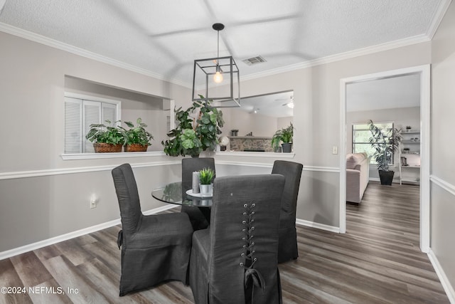 dining space with a textured ceiling, dark hardwood / wood-style floors, and crown molding