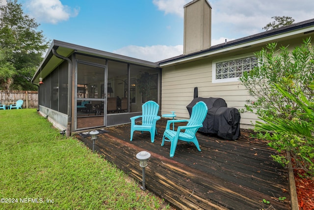 wooden deck featuring a yard and a sunroom