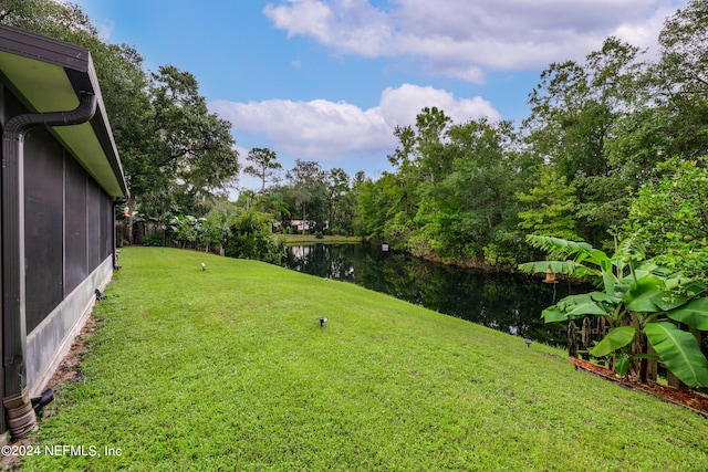 view of yard with a water view and a sunroom