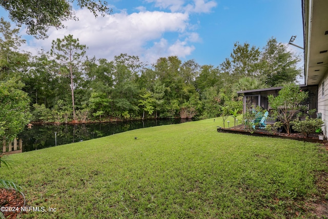 view of yard featuring a water view and a sunroom