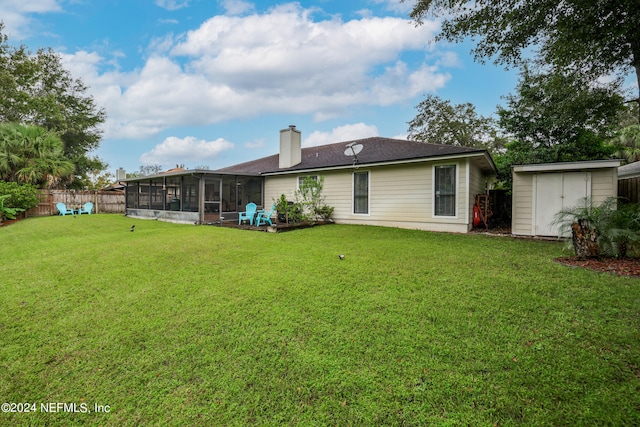 back of house with a storage shed, a sunroom, and a yard