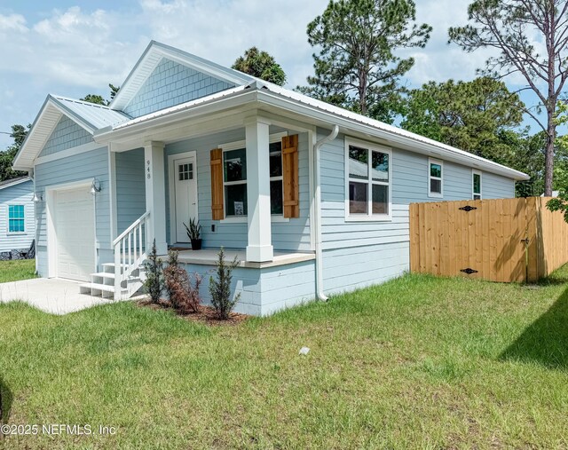 948 Collier Blvd, Saint Augustine, FL 32084 - view of front of home featuring a porch, a garage, concrete driveway, and metal roof