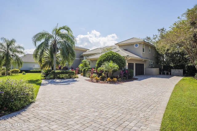 view of front of home with a garage and a front lawn