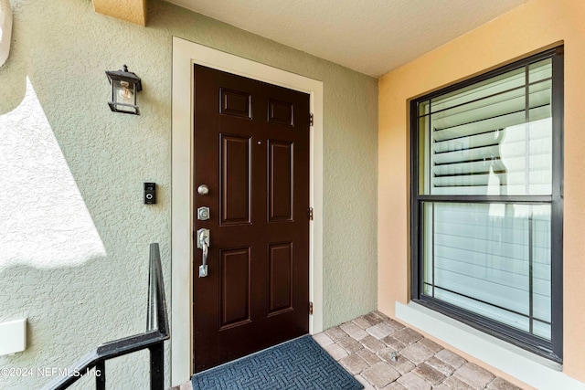 entrance to property featuring stucco siding