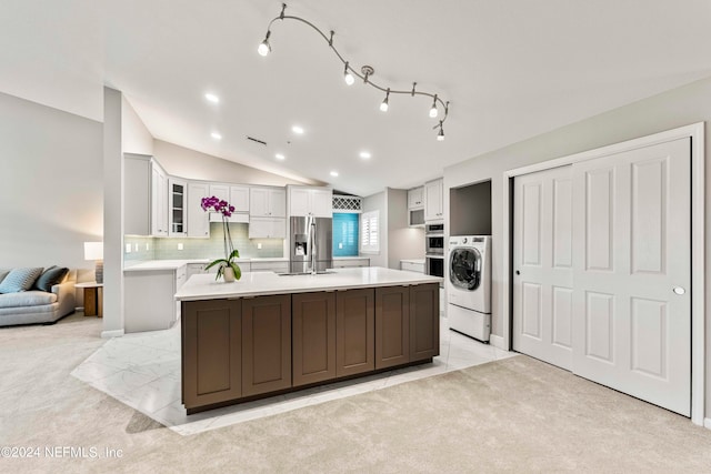 kitchen with light carpet, washer / clothes dryer, appliances with stainless steel finishes, and white cabinetry