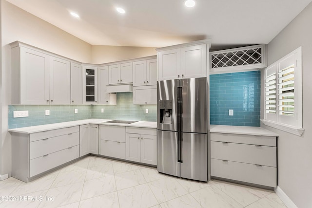 kitchen with under cabinet range hood, stainless steel fridge, marble finish floor, and light countertops