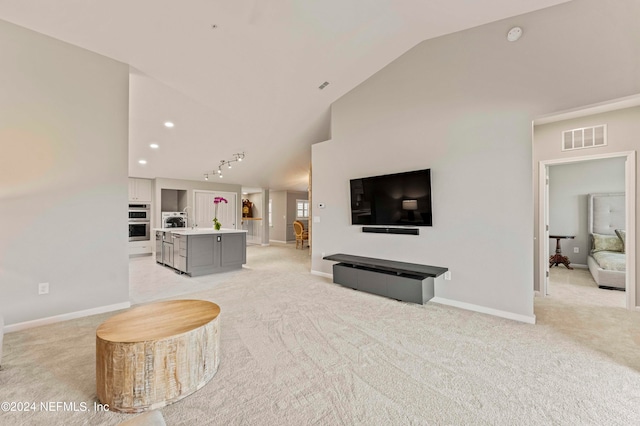 living room with light carpet, visible vents, baseboards, and vaulted ceiling