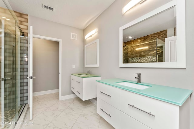 bathroom featuring vanity, a shower with shower door, and a textured ceiling