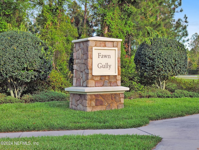 community / neighborhood sign featuring a yard