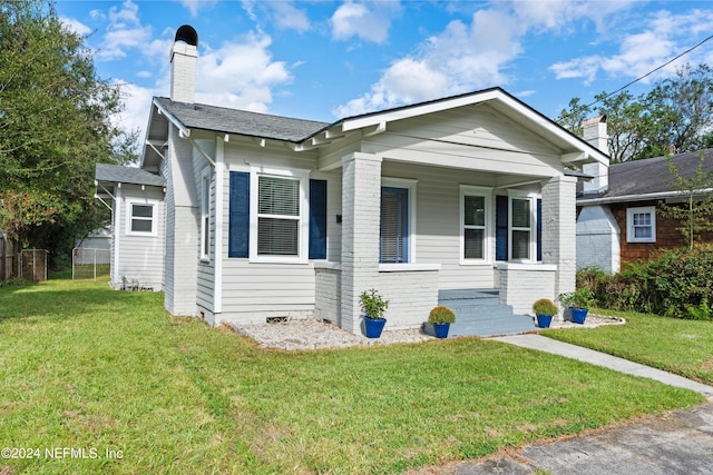 view of front of house featuring covered porch and a front lawn