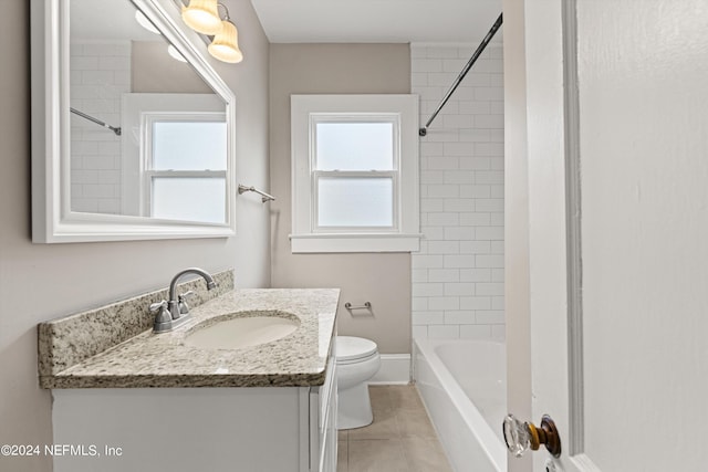 full bathroom with tile patterned floors, vanity, tiled shower / bath combo, and toilet