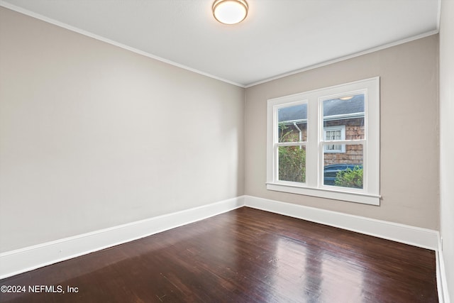 empty room with hardwood / wood-style floors and crown molding