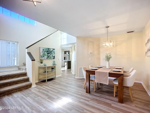 dining space with a chandelier and light wood-type flooring