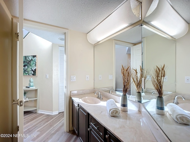 bathroom with vanity, a textured ceiling, and hardwood / wood-style flooring