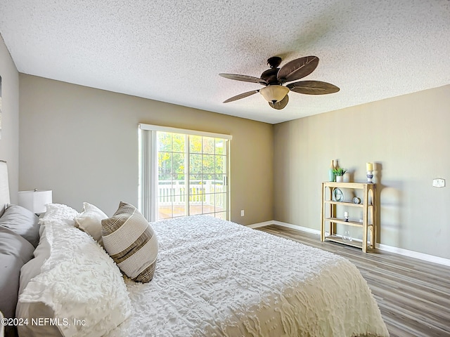 bedroom with wood-type flooring, a textured ceiling, access to outside, and ceiling fan